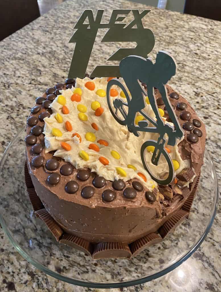 Birthday cake with bicyclist cake topper riding down the cake