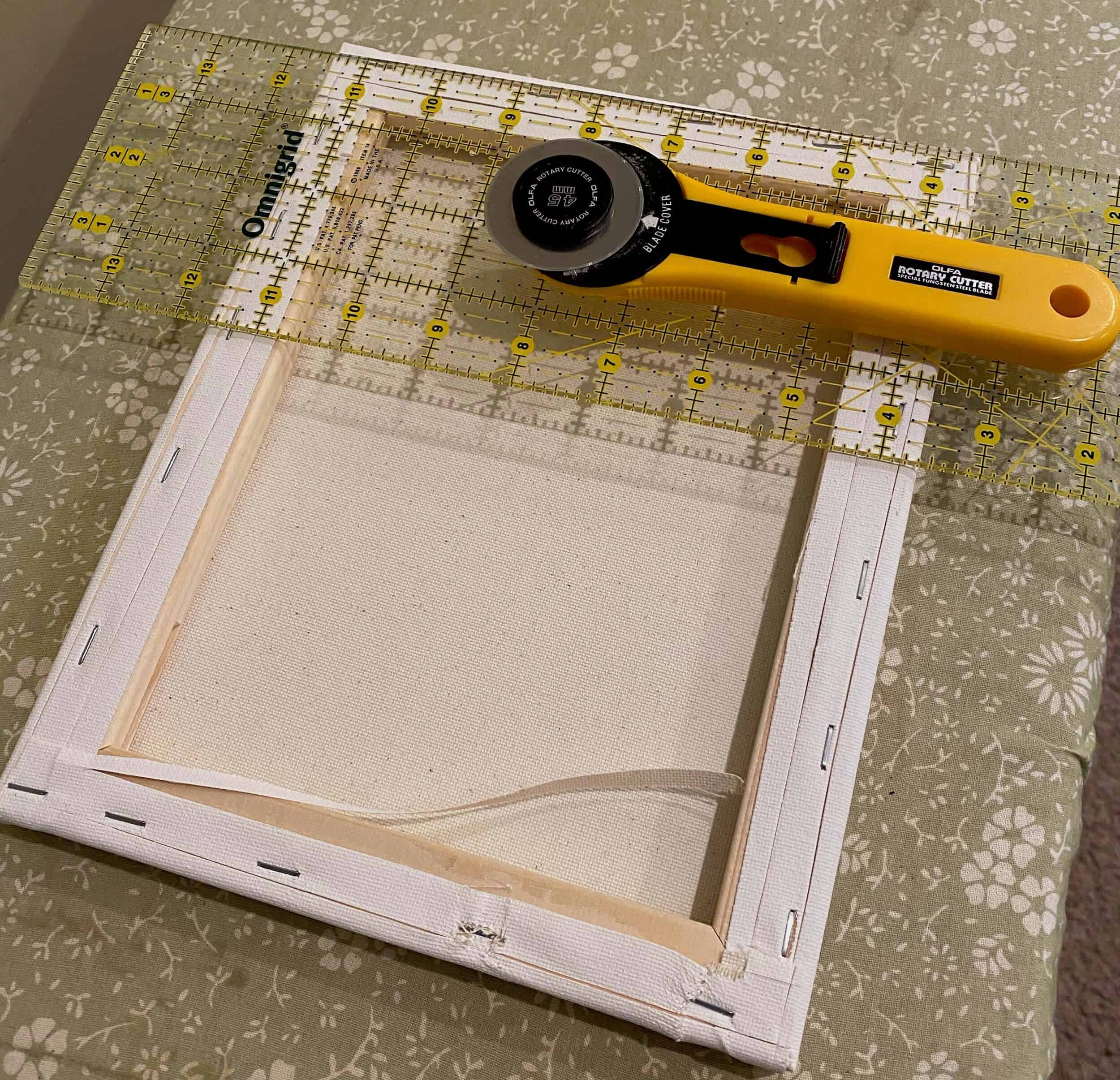cutting a wrapped canvas off its frame for reverse canvas tutorial