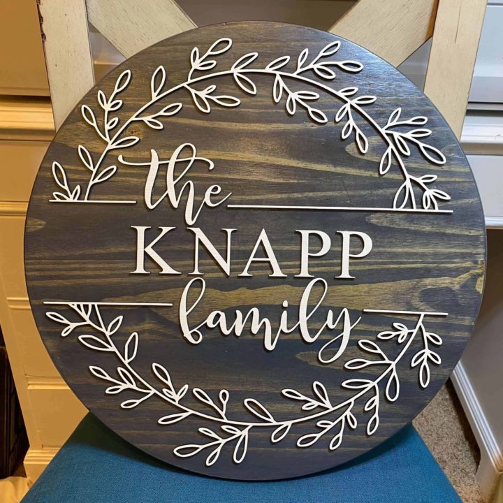 stained wood round with cream painted letters